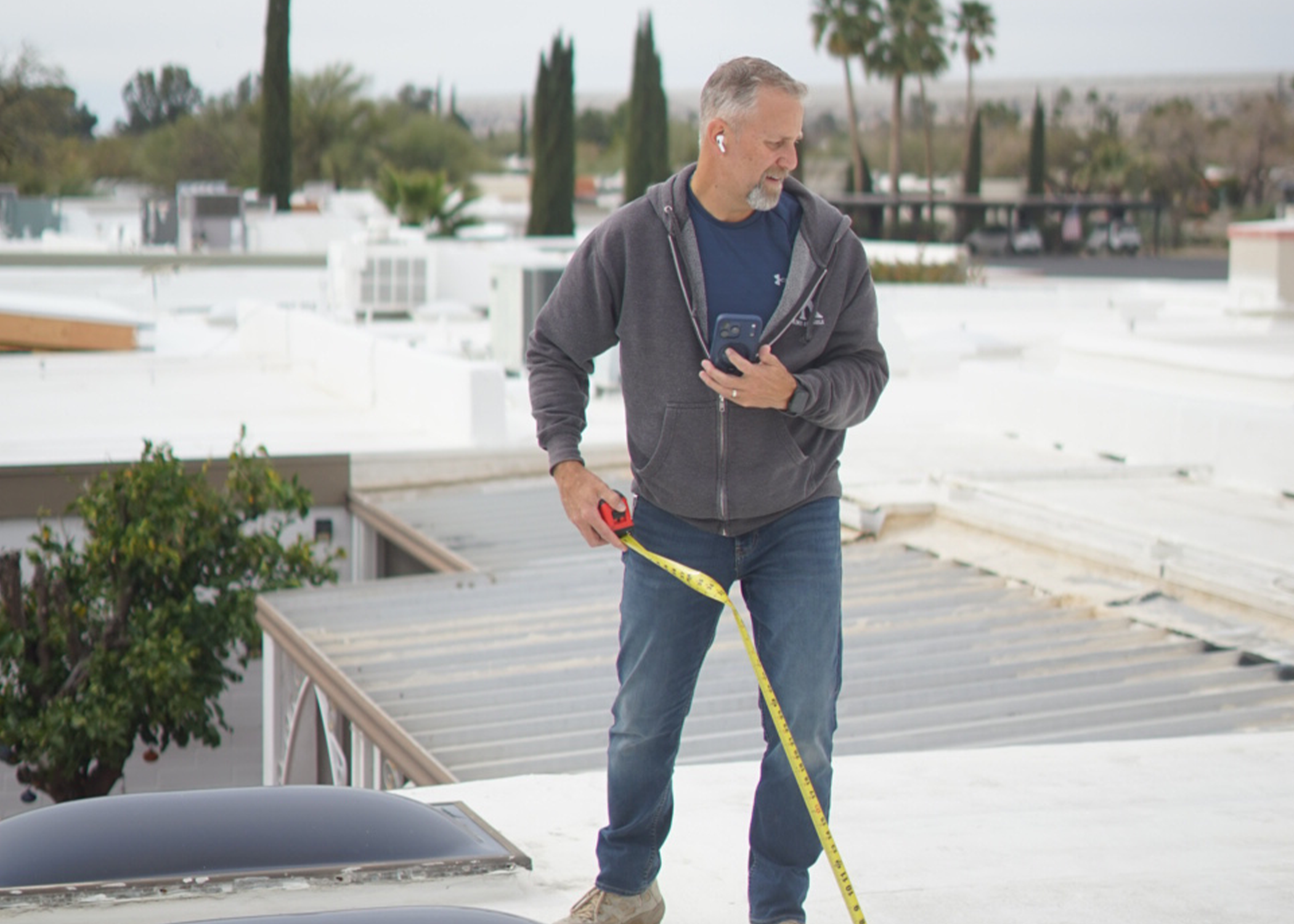 Owner of DSR inspecting a roof and measuring skylights in Green Valley, Southern Arizona.